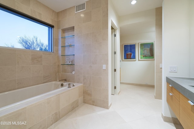 bathroom featuring tile patterned floors, tiled tub, and vanity