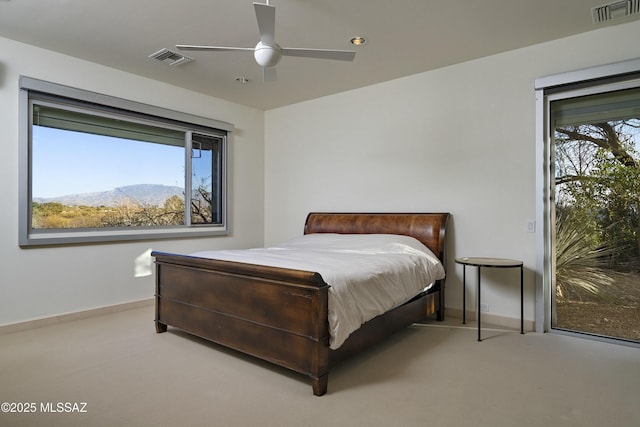 carpeted bedroom featuring ceiling fan and a mountain view