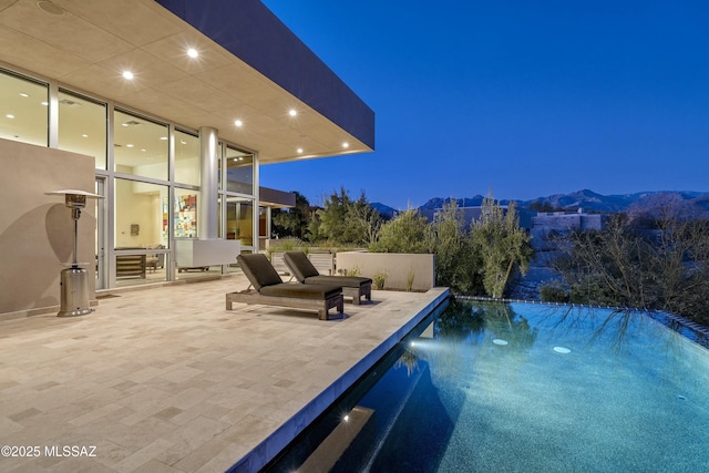 view of pool with a mountain view and a patio