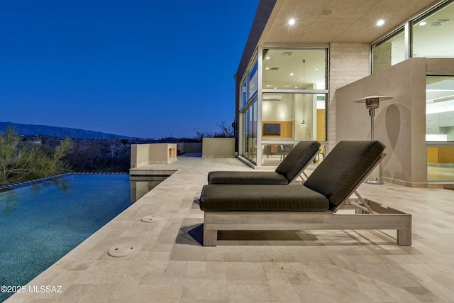 patio at twilight featuring a mountain view