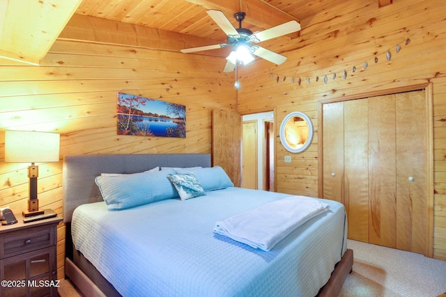 carpeted bedroom with ceiling fan, wood ceiling, and wooden walls