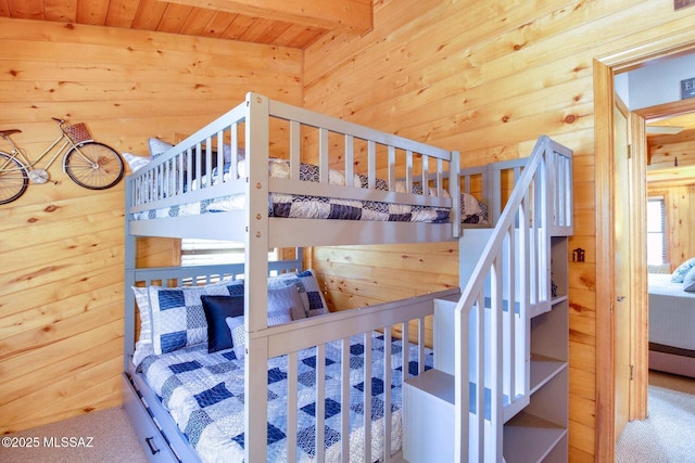 bedroom with wood walls and carpet flooring