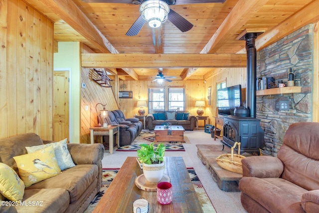 carpeted living room with beam ceiling, wood ceiling, wood walls, and a wood stove