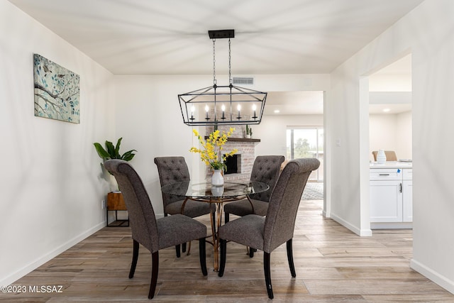 dining space featuring light hardwood / wood-style flooring and a fireplace