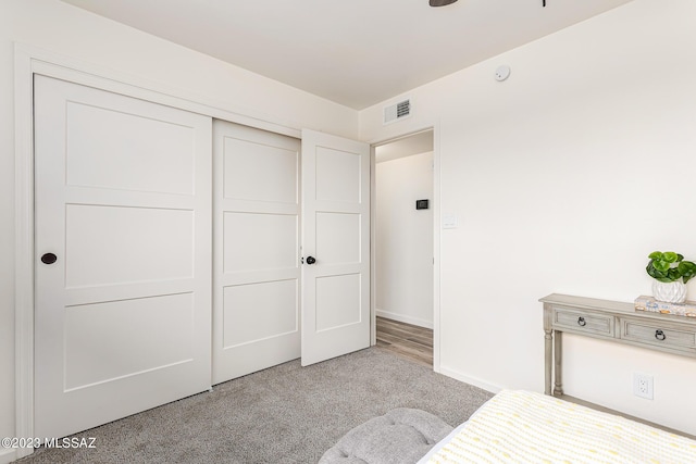 unfurnished bedroom with light colored carpet and a closet