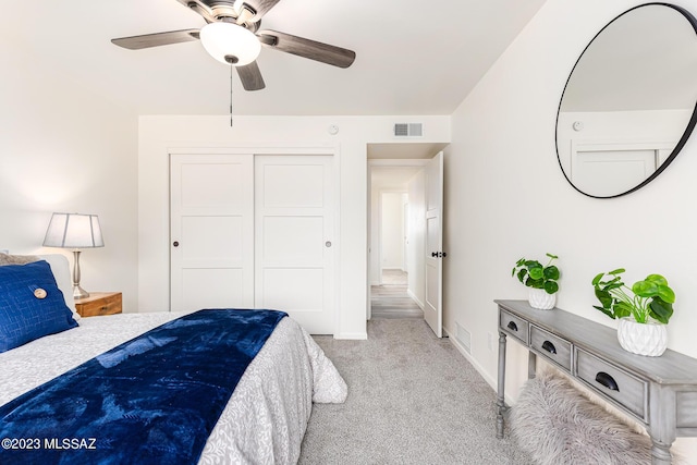 bedroom featuring a closet, ceiling fan, and light carpet