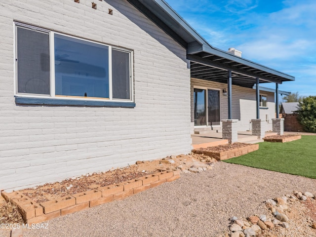 view of property exterior with a patio and a lawn