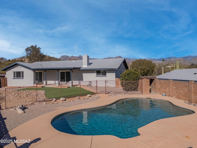 view of swimming pool featuring a patio and a mountain view