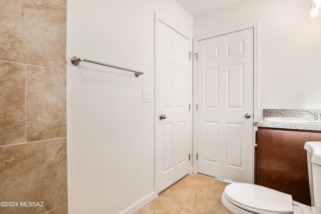 bathroom with toilet, tile patterned floors, and vanity