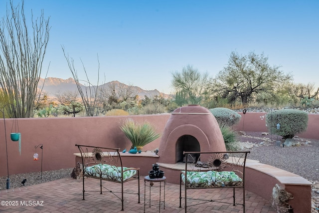 view of patio featuring an outdoor fireplace and a mountain view