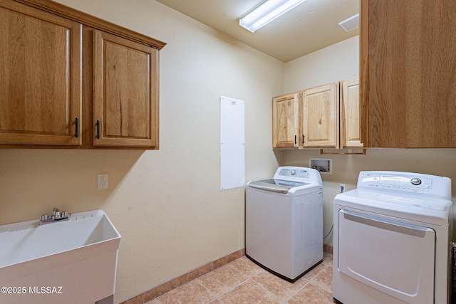 laundry area featuring cabinets, sink, light tile patterned floors, and washing machine and clothes dryer