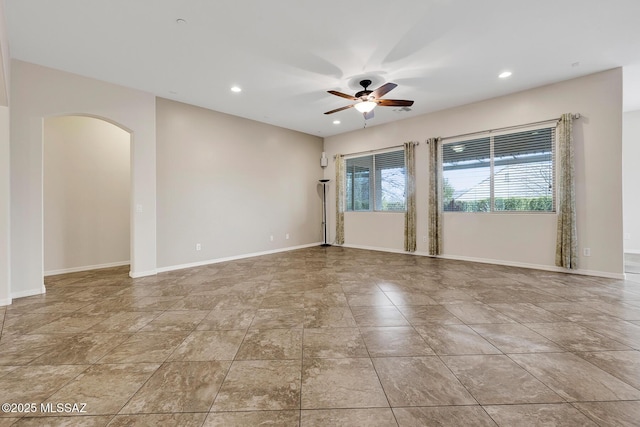 tiled empty room featuring ceiling fan