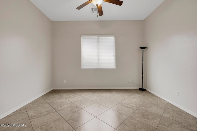 empty room with ceiling fan and light tile patterned floors