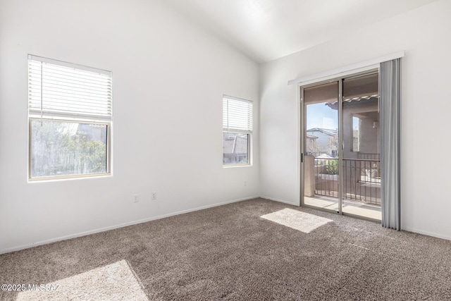 carpeted empty room featuring lofted ceiling