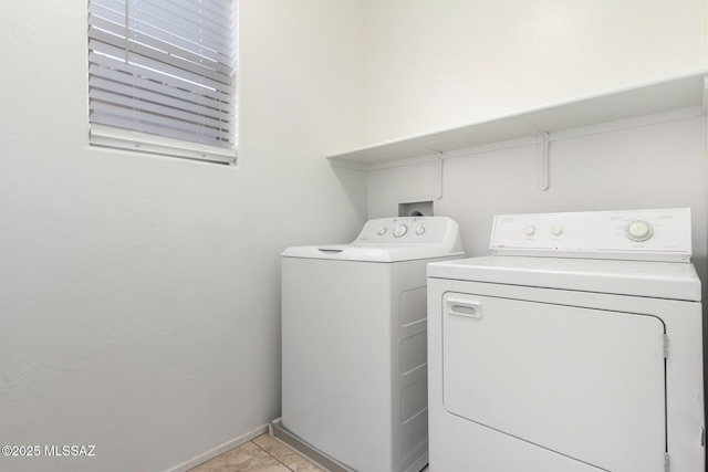 clothes washing area featuring washer and dryer and light tile patterned flooring