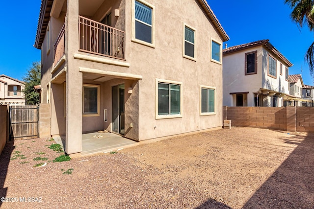 back of house with a balcony and a patio