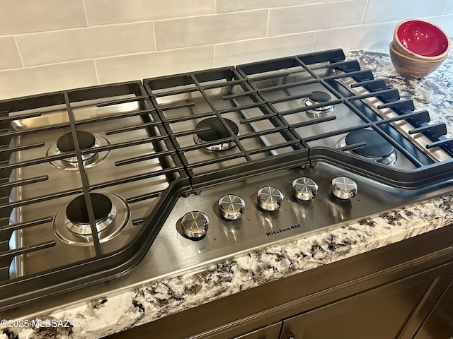 room details featuring stainless steel gas stovetop and decorative backsplash