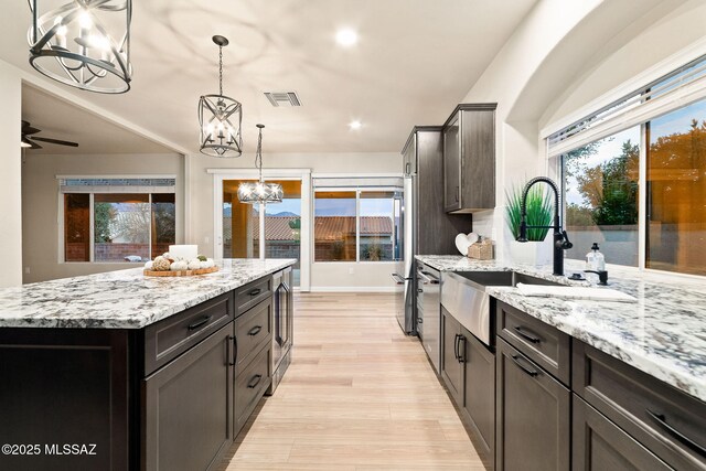 kitchen with high end fridge, dark brown cabinets, and a center island