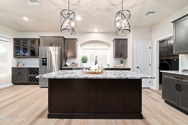 kitchen featuring high quality fridge, dark brown cabinets, and a center island