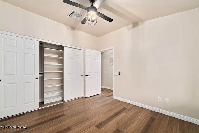 unfurnished bedroom featuring lofted ceiling, hardwood / wood-style floors, a closet, and ceiling fan