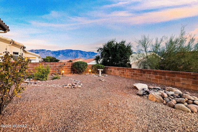 yard at dusk featuring a mountain view