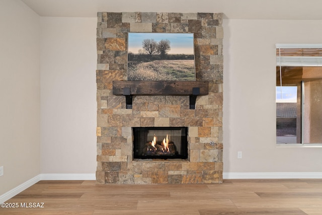 interior details featuring hardwood / wood-style flooring and a stone fireplace