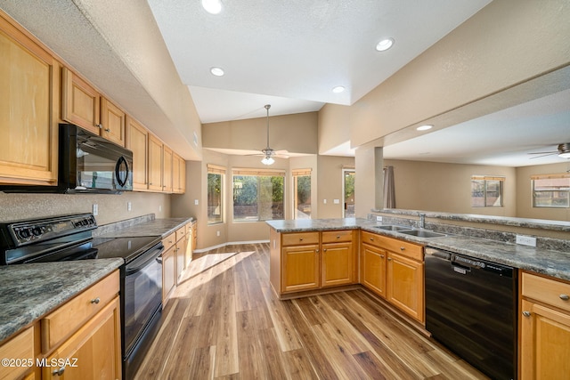 kitchen featuring lofted ceiling, sink, light wood-type flooring, ceiling fan, and black appliances