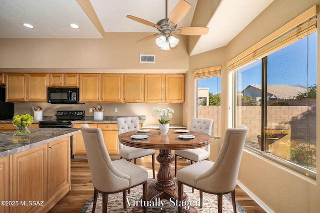 kitchen featuring dark wood-type flooring, ceiling fan, light brown cabinets, and black appliances