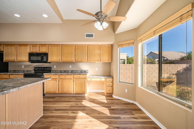 kitchen featuring built in desk, light brown cabinets, hardwood / wood-style flooring, ceiling fan, and black appliances