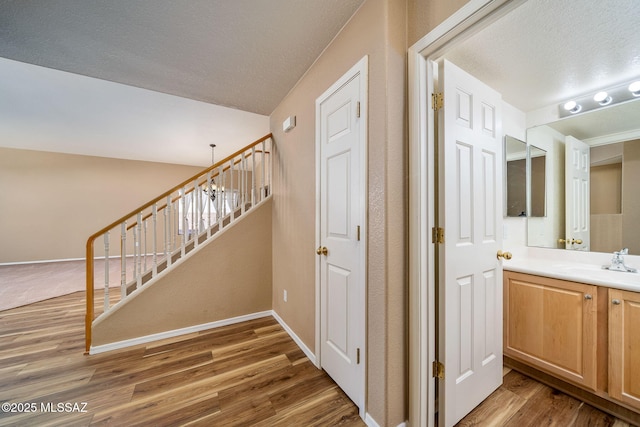 interior space featuring wood-type flooring, sink, and a textured ceiling