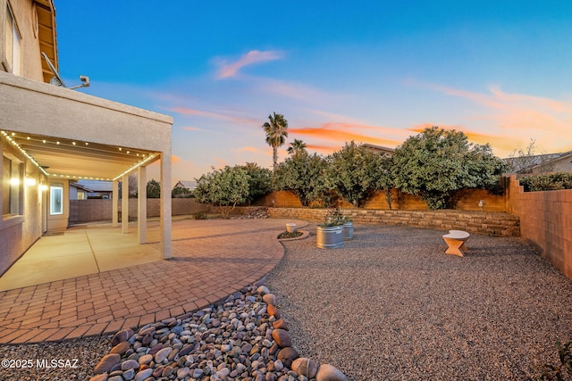 yard at dusk with a patio area