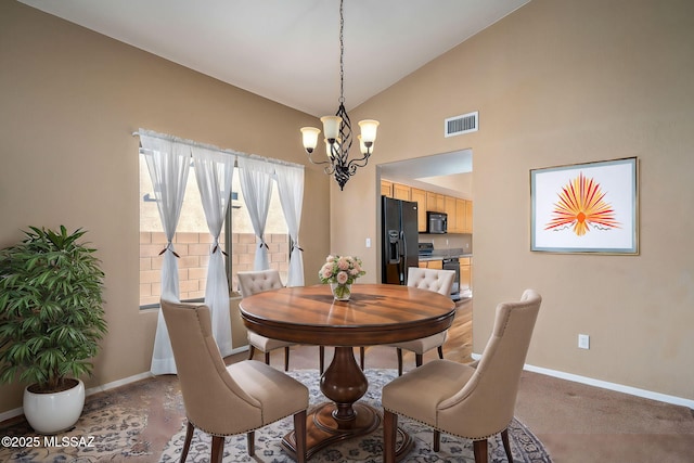 dining room featuring high vaulted ceiling, carpet floors, and a chandelier