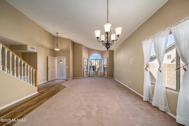 interior space with an inviting chandelier, carpet flooring, and high vaulted ceiling