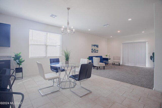 kitchen featuring decorative light fixtures, stainless steel dishwasher, an inviting chandelier, a kitchen island with sink, and light stone counters