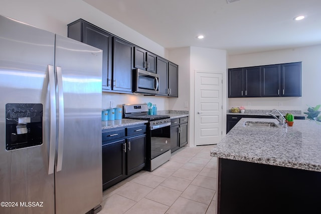 kitchen with sink, light stone counters, light tile patterned floors, and stainless steel appliances