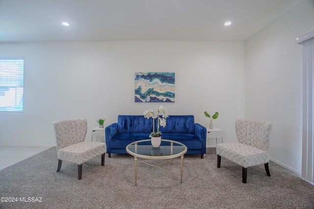 carpeted living room with an inviting chandelier