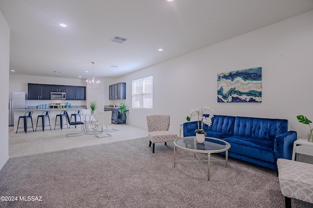 carpeted living room featuring a notable chandelier