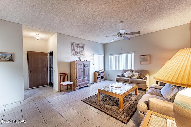 living room with a textured ceiling, ceiling fan, and light tile patterned floors