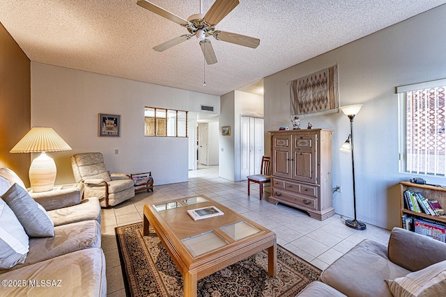 tiled living room featuring a textured ceiling and ceiling fan