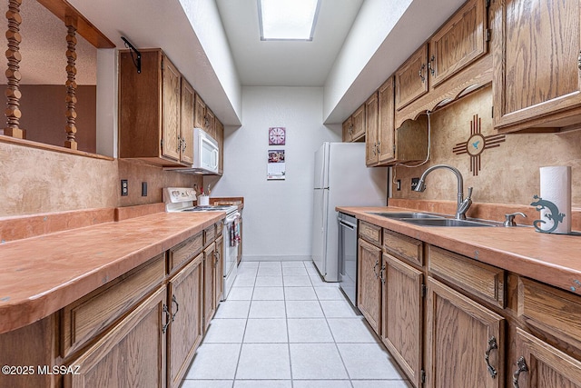 kitchen with white appliances, tasteful backsplash, sink, and light tile patterned floors