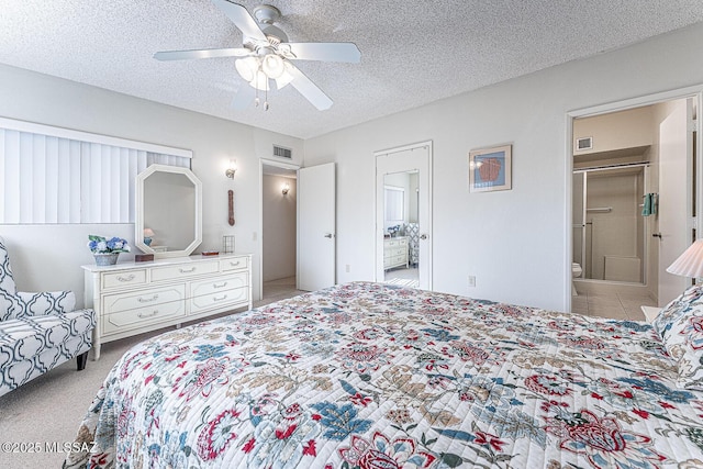 carpeted bedroom with ensuite bath, a textured ceiling, and ceiling fan