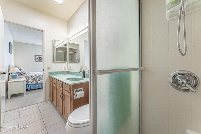 bathroom with tile patterned flooring, an enclosed shower, vanity, and toilet