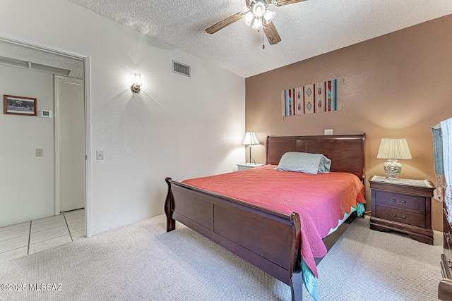 bedroom with a textured ceiling, light colored carpet, and ceiling fan