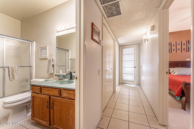 full bathroom featuring a textured ceiling, toilet, tile patterned floors, bath / shower combo with glass door, and vanity