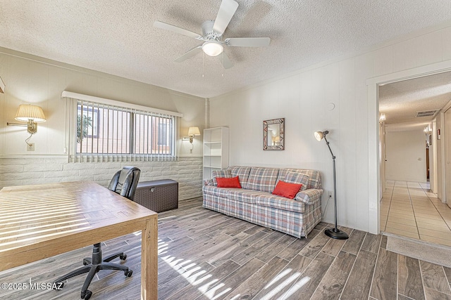 home office featuring ceiling fan and a textured ceiling