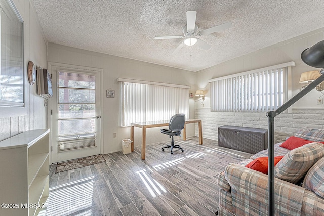 home office with a textured ceiling, ceiling fan, and hardwood / wood-style flooring