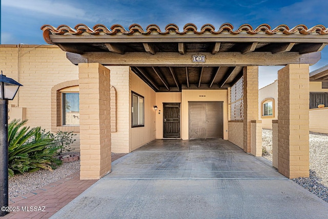 doorway to property featuring elevator and a carport