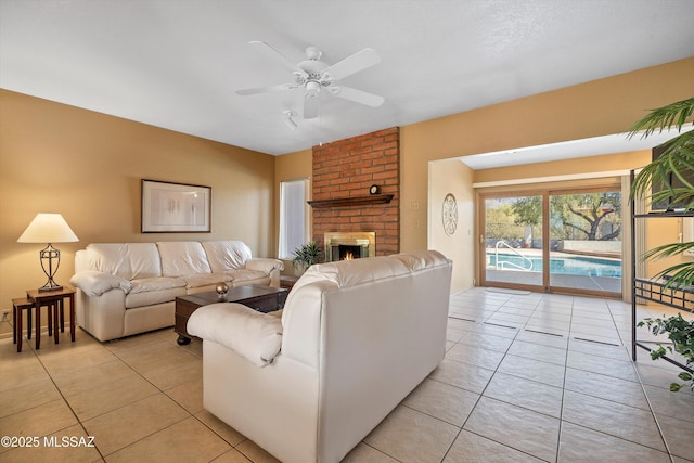 living room featuring ceiling fan, light tile patterned floors, and a fireplace