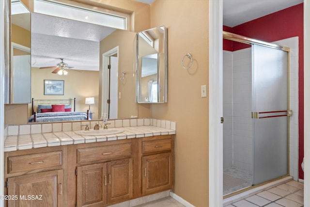 bathroom featuring walk in shower, ceiling fan, vanity, and tile patterned flooring