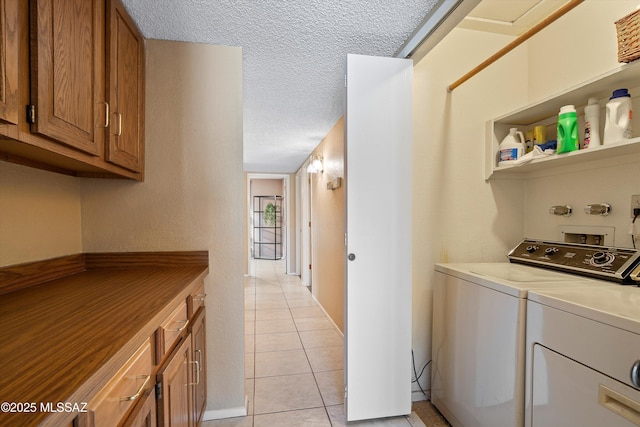 washroom with independent washer and dryer, a textured ceiling, and light tile patterned floors